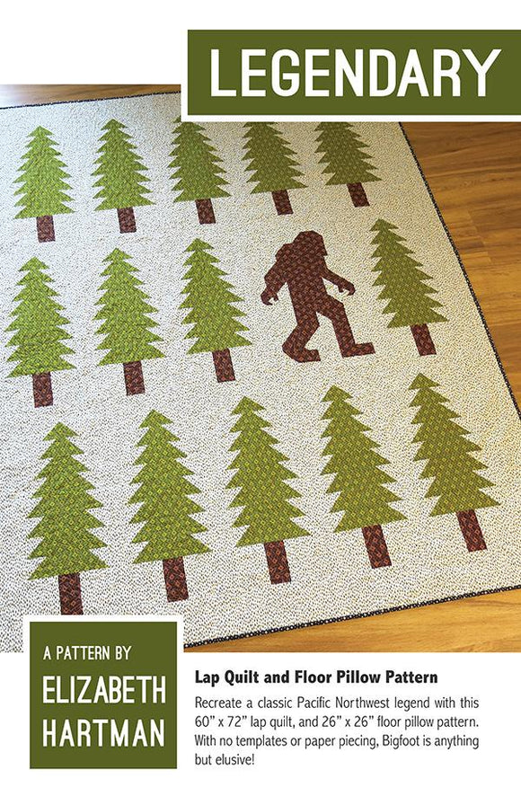 Legendary quilt pattern by Elizabeth Hartman depict a big foot Sasquatch walking through a forest of pine trees. 