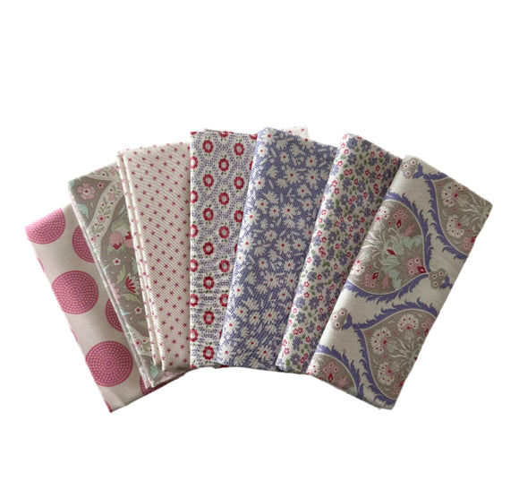 Set of six patterned fat quarters from Tilda Fabrics swatches on a light gray background with blues and pinks. 